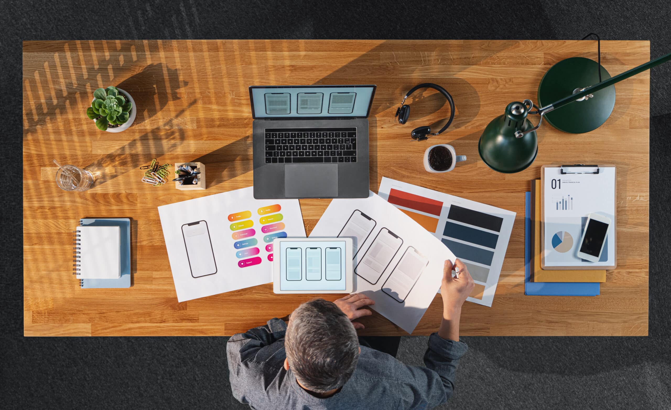 top view of creative businessman working on computer at desk in home office.
