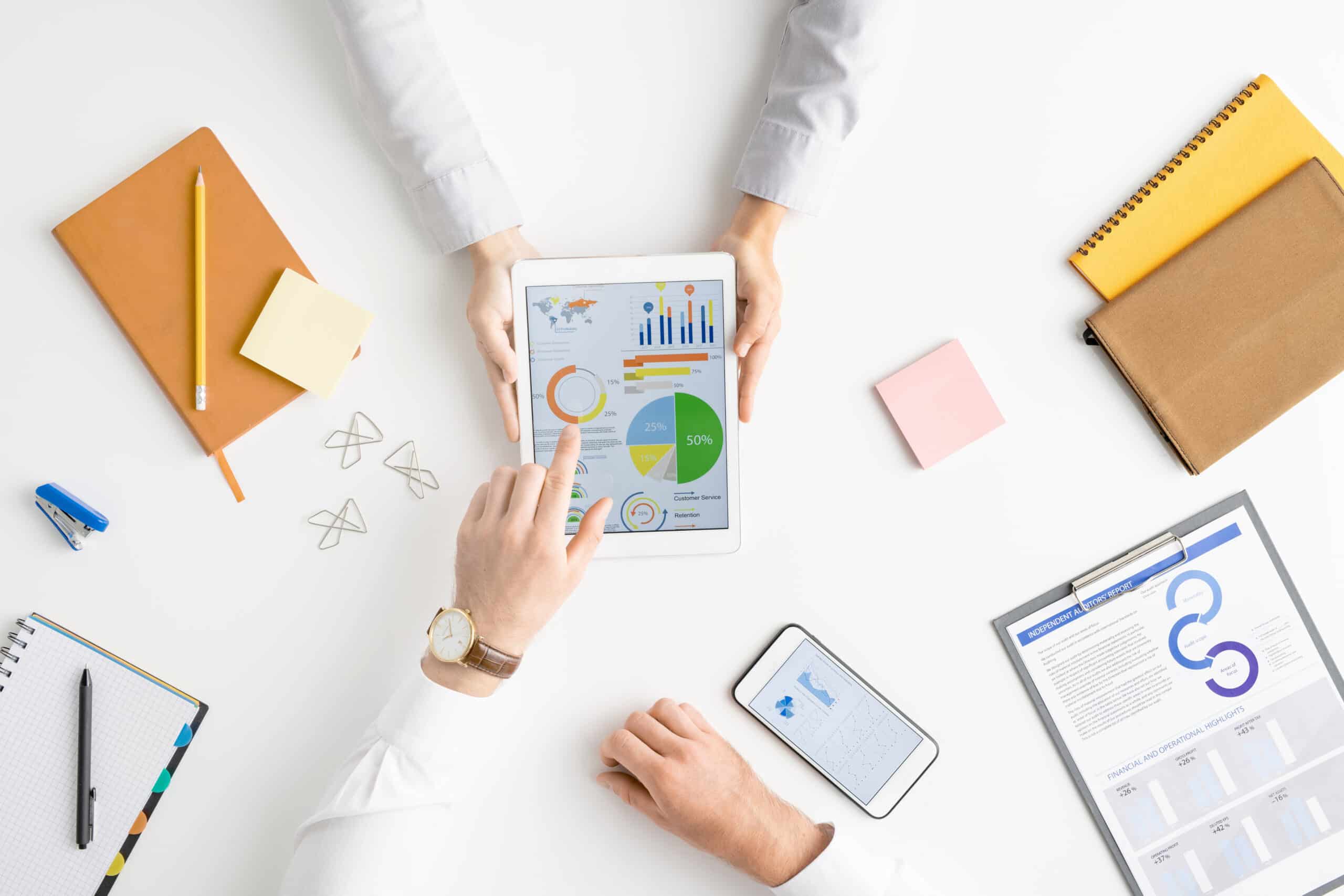 view of hands of two contemporary analysts or brokers discussing financial data